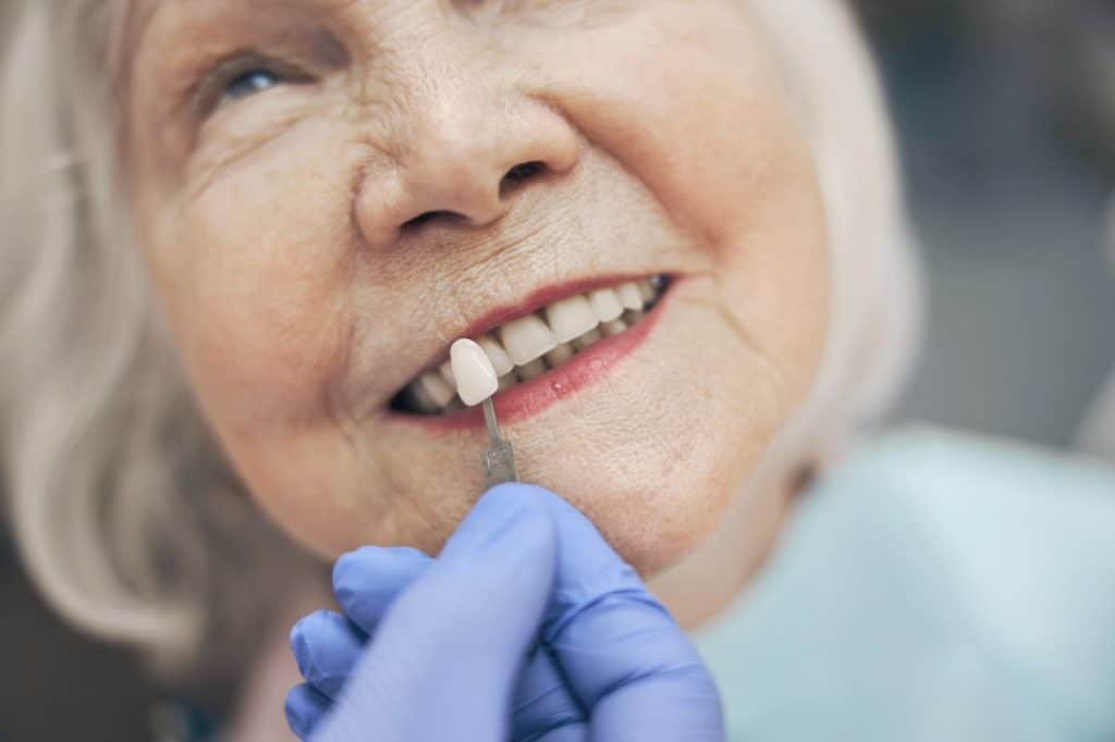 Senior patient receiving a hybrid denture fitting at Prestige Dental of Humble, TX, ensuring a natural-looking and secure smile restoration.